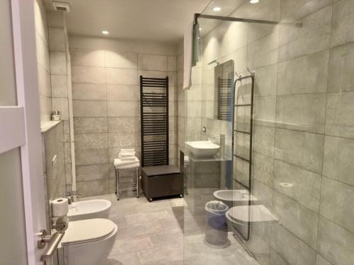 a bathroom with two sinks and a toilet and a sink at Hotel Europa Varese in Varese
