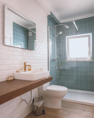 a bathroom with a sink and a toilet and a shower at Guesthouse Beach Break in Peniche