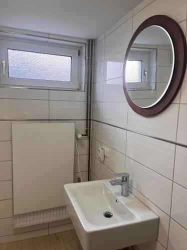 a white bathroom with a sink and a mirror at NR 2 EG 3 ZKB für Firmen und Familien in Vellmar