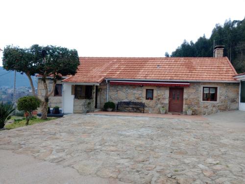 a house with a stone driveway in front of it at O Refuxio de Tebra in Tebra