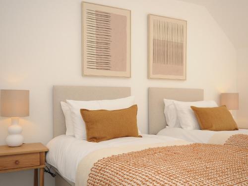 two beds sitting next to each other in a bedroom at Wharfside in Penzance