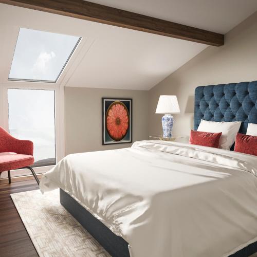 a bedroom with a large white bed and a red chair at Charming House - O Mercado in Ponta Delgada