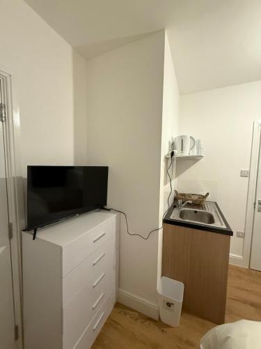 a small kitchen with a sink and a microwave at Gray Bridge House in Kingsthorpe