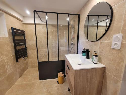 a bathroom with a shower and a sink and a mirror at Appartement au cœur du golf in Pont-de-Larn