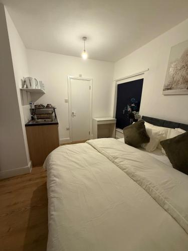 a bedroom with a white bed and a window at Gray Bridge House in Kingsthorpe