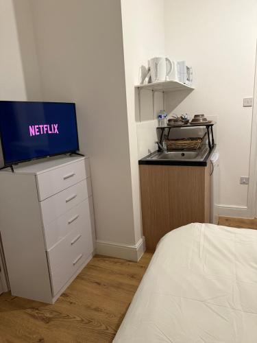 a room with a bed and a tv on a dresser at Gray Bridge House in Kingsthorpe