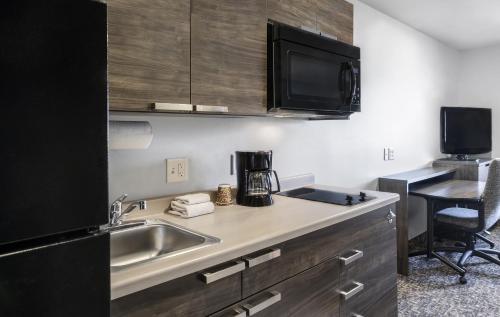 a kitchen with a sink and a microwave at My Place Hotel-Phoenix West/Avondale, AZ in Avondale