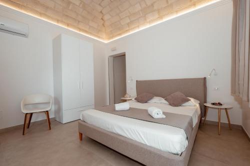 a bedroom with a large bed and a chair at Cala di Ponente in Castelluzzo