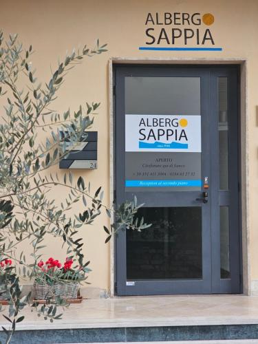 a sign on the side of a building with a door at Albergo Sappia in Arma di Taggia