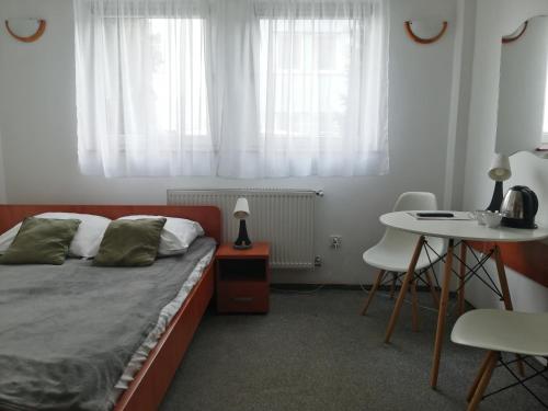 a bedroom with a bed and a table and window at Hotel Dąbrowiak in Dąbrowa Górnicza