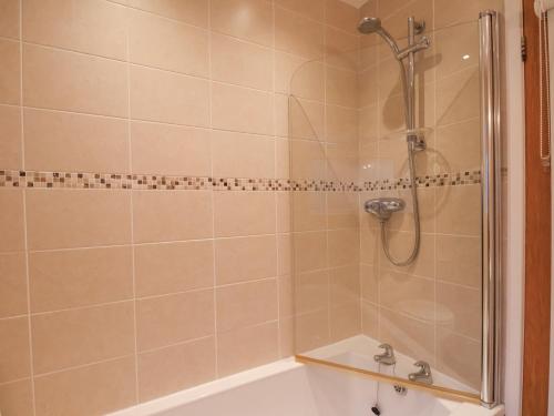 a bathroom with a shower and a bath tub at Meadow Cottage in Scarborough