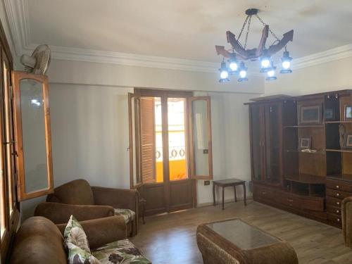 a living room with a couch and a chandelier at cozy penthouse in New Cairo in Kharga