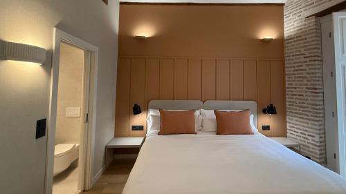 a bedroom with a large white bed with two pillows at Cosy Rooms Embajador in Valencia
