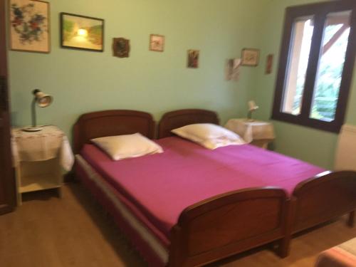 a bedroom with a bed with purple sheets and a window at La vue sur mer in La Croix-Valmer