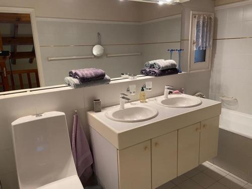 une salle de bain avec deux lavabos et un miroir dans l'établissement Mas lou beu, au Lavandou