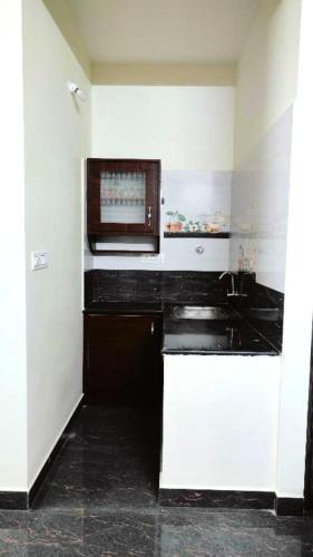 a kitchen with a microwave and a black counter at Samuels Comfort Homes in Bengaluru