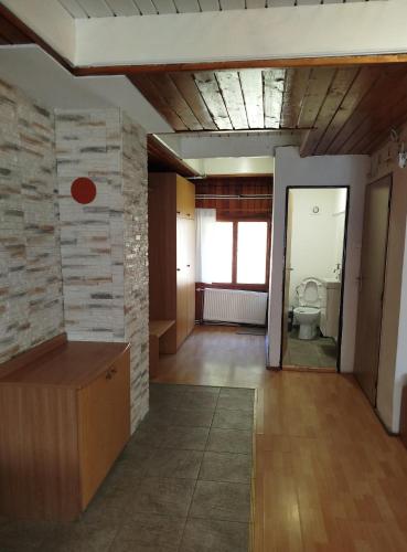 a living room with a stone wall and a bathroom at Chata Žiar in Rajecká Lesná