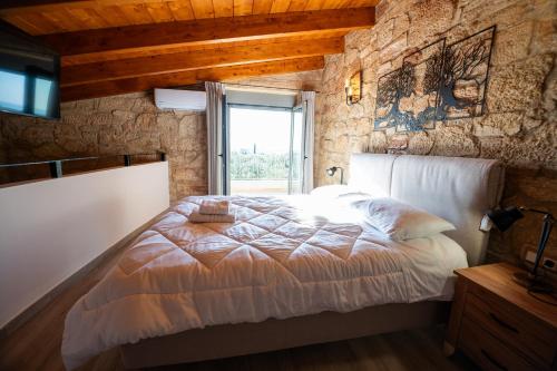 a bedroom with a large bed with a window at Entheon Olive Villas - Poolside Retreats in Marathopolis