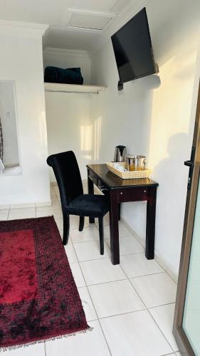 a dining room with a table and a chair at Township Lodge -Seshego in Polokwane