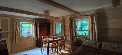 a room with a table and chairs and windows at Chata Wilczka in Miedzygorze