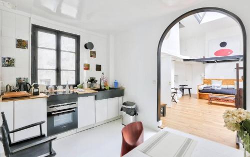 une cuisine ouverte et un salon avec une arche dans l'établissement Apartment on Rue Pierre Fontaine, à Paris