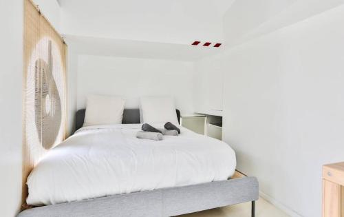 une chambre avec un lit blanc avec deux oreillers dessus dans l'établissement Apartment on Rue Pierre Fontaine, à Paris
