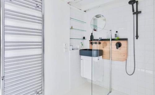 une salle de bain avec un lavabo et une douche dans l'établissement Apartment on Rue Pierre Fontaine, à Paris