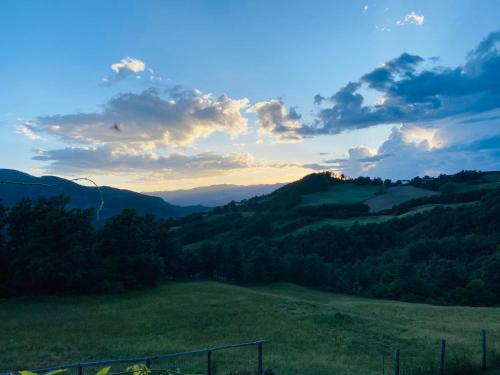 a view of a green field with trees and a sunset at La Lupa e l'Orso in Berceto