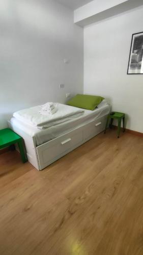 a white bed in a room with a wooden floor at Bed&Breakfast Angela in Clusone