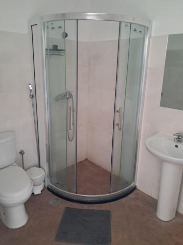 a shower in a bathroom with a toilet and a sink at Cacimba Sunset Lodge in Tarrafal