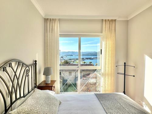 a bedroom with a bed and a large window at El pisito de Carmen in Portosin