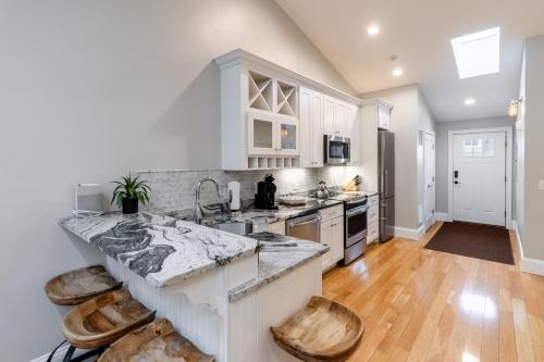 a kitchen with a marble counter top and wooden floors at The Newport Lofts - 359 Thames Street in Newport