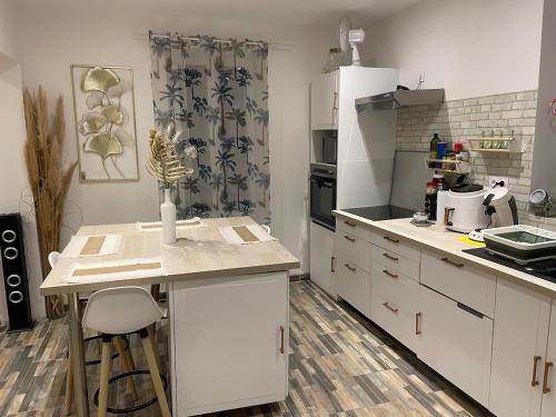 une cuisine avec des armoires blanches et un comptoir dans l'établissement cozy house, à Chabris