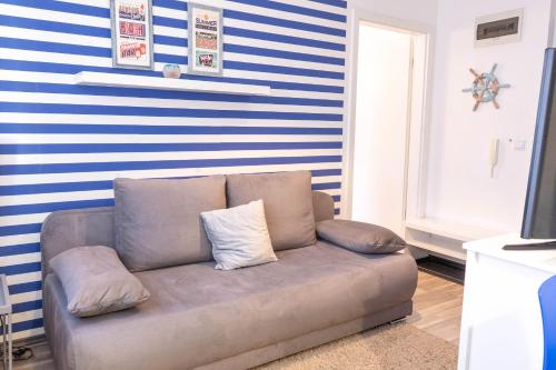 シオーフォクにあるCAC Wellness Apartmentの青と白のストライプの壁のリビングルーム(ソファ付)