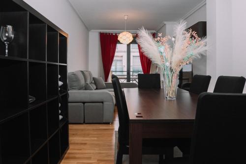 a dining room with a table and a living room at Vistas al mar en el centro by CABANA Rentals in Moaña