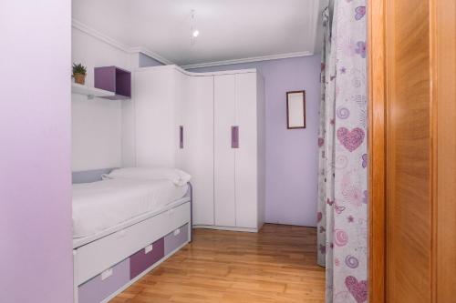 a small bedroom with a bed and a closet at Vistas al mar en el centro by CABANA Rentals in Moaña