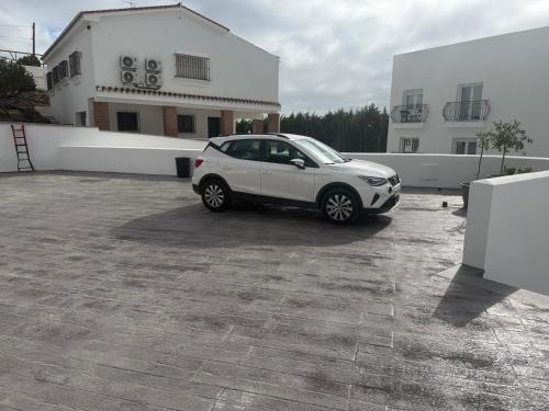 a white car parked in a parking lot at La familia Apartaments Mijas Pueblo in Mijas