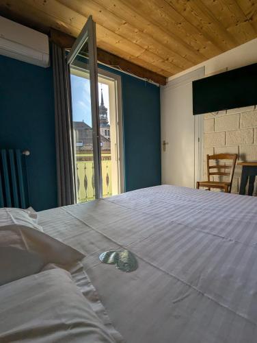 a bedroom with a large bed with a large window at Hôtel Du Midi in Thônes