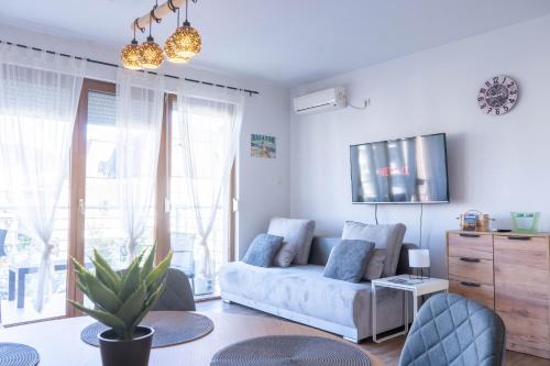 a living room with a couch and a tv at MWellness Apartment in Siófok