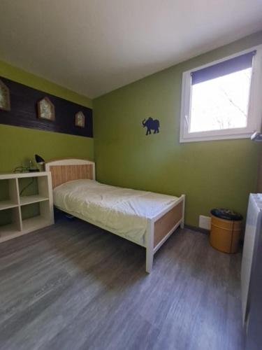 a small bedroom with a bed and a window at Appartement terrasse +parking in Vieille-Brioude