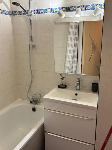 a bathroom with a sink and a tub and a shower at Appartement secteur village rez-de-chaussée avec terrasse et parking 50m mer in Le Barcarès