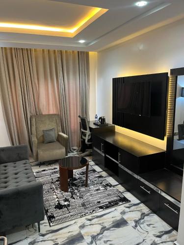 a living room with a large flat screen tv at Roston Hotels in Port Harcourt