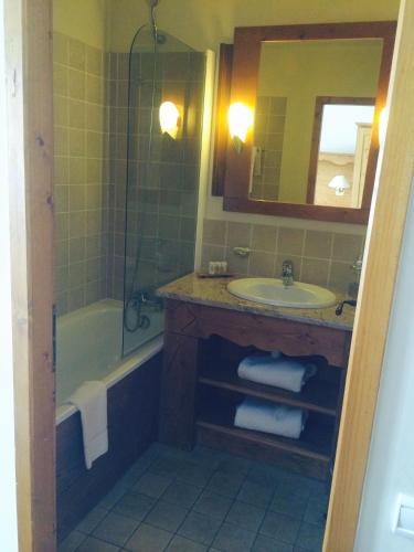 une salle de bain avec une baignoire, un lavabo et un miroir dans l'établissement ARCS 1950 Prince des Cimes 2 chambres 6 pers orienté sud ouest Piscine Jacuzzi Sauna Hammam, à Arc 1950