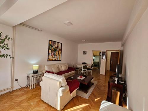a living room with a couch and a table at Lovely square apartment Purple Velvet 43 Macedonia Stree in Skopje
