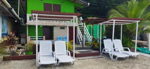 a group of chairs and an umbrella in front of a house at Ofiuras Hostal in Colón