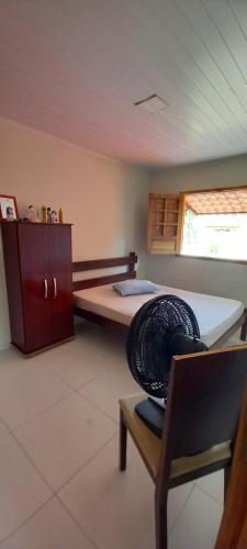 ein Zimmer mit einem Bett mit einem Stuhl und einem Tisch in der Unterkunft Yellow House Itapuama in Cabo de Santo Agostinho