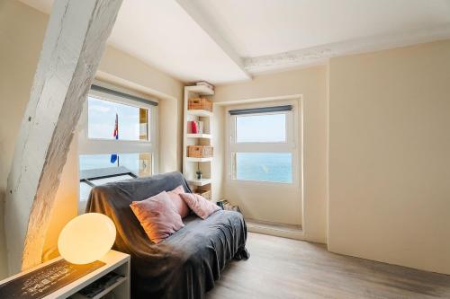 a living room with a leather couch and a window at T2 dans l'intra-Muros VUE MER exceptionnelle in Saint Malo