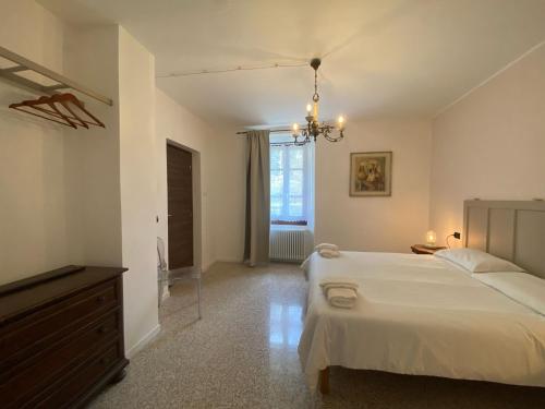a bedroom with a large white bed and a dresser at La Lupa e l'Orso in Berceto