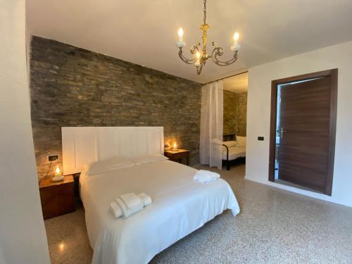 a bedroom with a white bed and a brick wall at La Lupa e l'Orso in Berceto