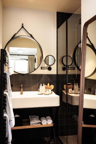 a bathroom with a sink and a mirror at Domaine de Locguénolé & Spa - Relais & Chateaux in Kervignac